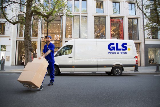 Een bezorger draagt pakketten op een steekkar