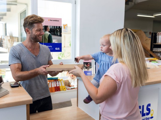 GLS parcel shop - muž vydává ženě balíček