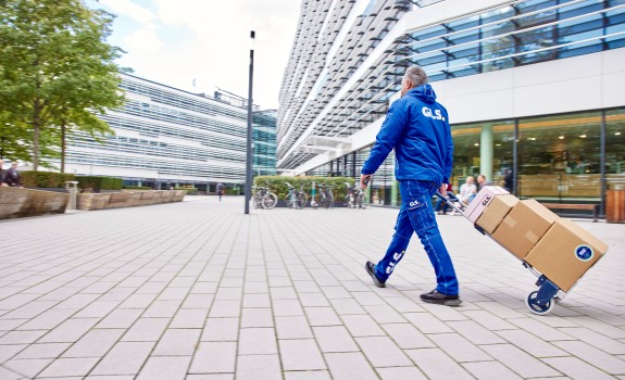 GLS-työntekijä kuljettaa paketteja kaupungilla