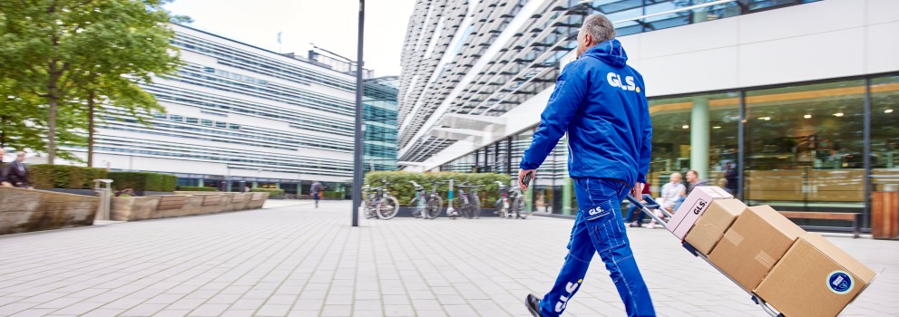 GLS-työntekijä kuljettaa paketteja kaupungilla