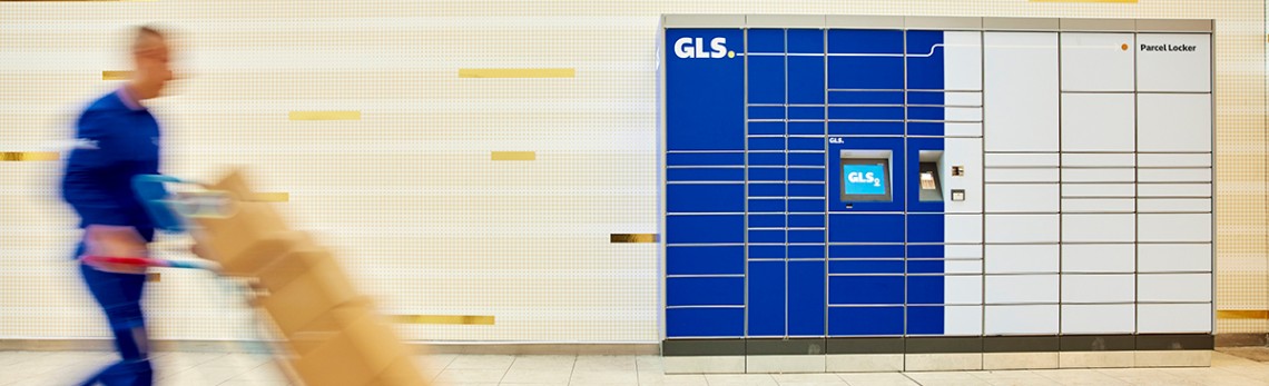 Futár csomagokat visz a GLS automatához